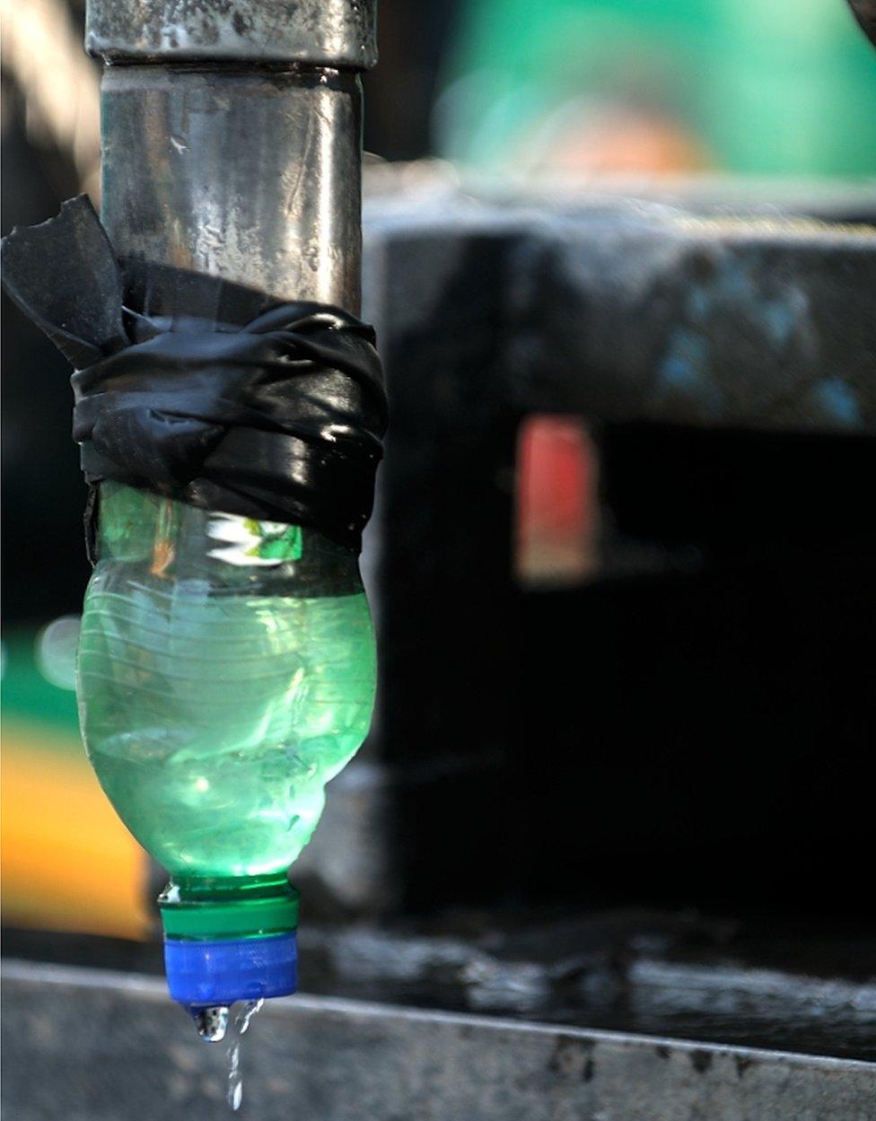 A water bottle tied to a pipe.