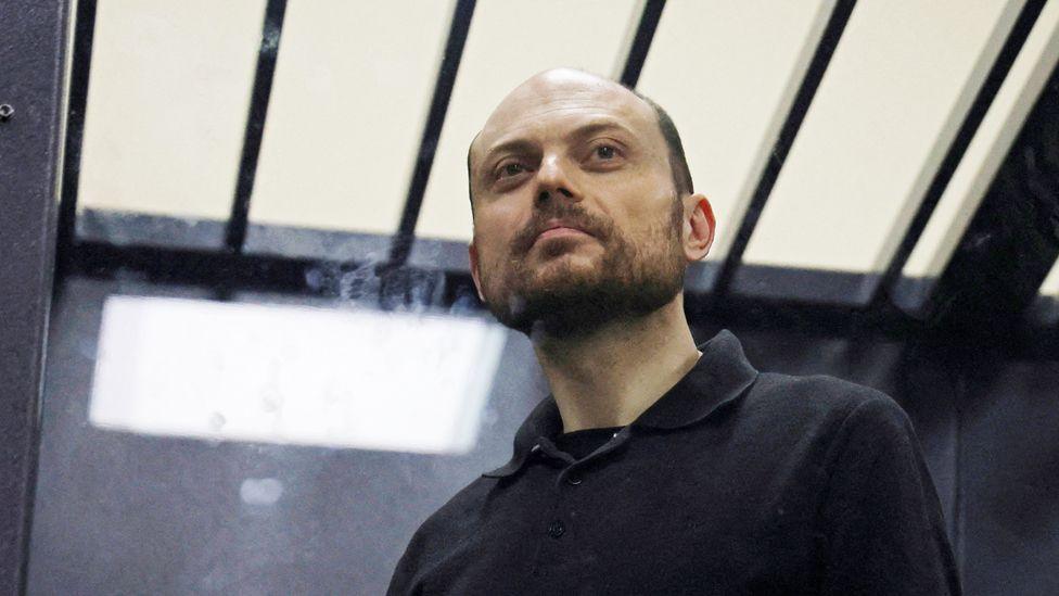 Jailed Russian opposition figure Vladimir Kara-Murza stands behind a glass wall