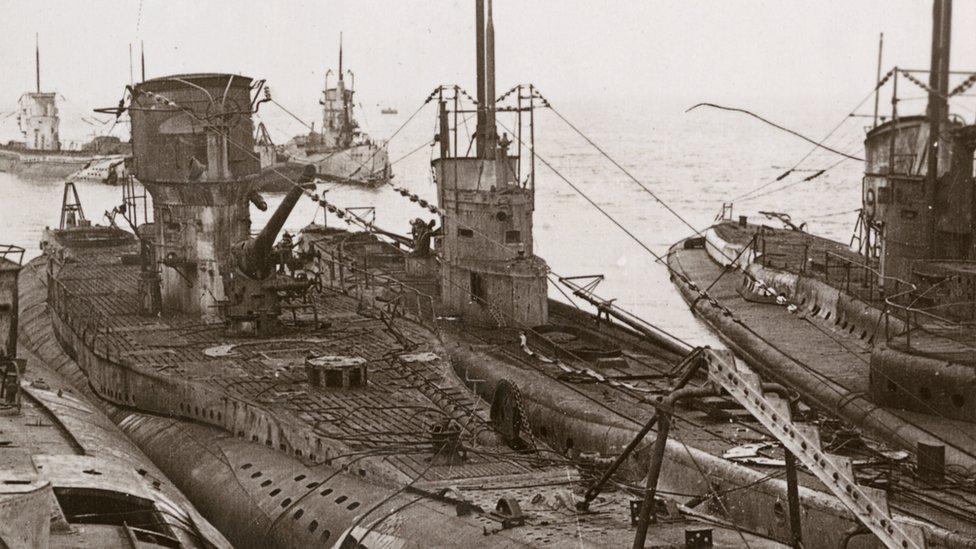 A stereo card image of German submarines moored at Harwich at the end of World War I, November 1918. The vessels were surrendered to Britain under the terms of the armistice signed by Germany.