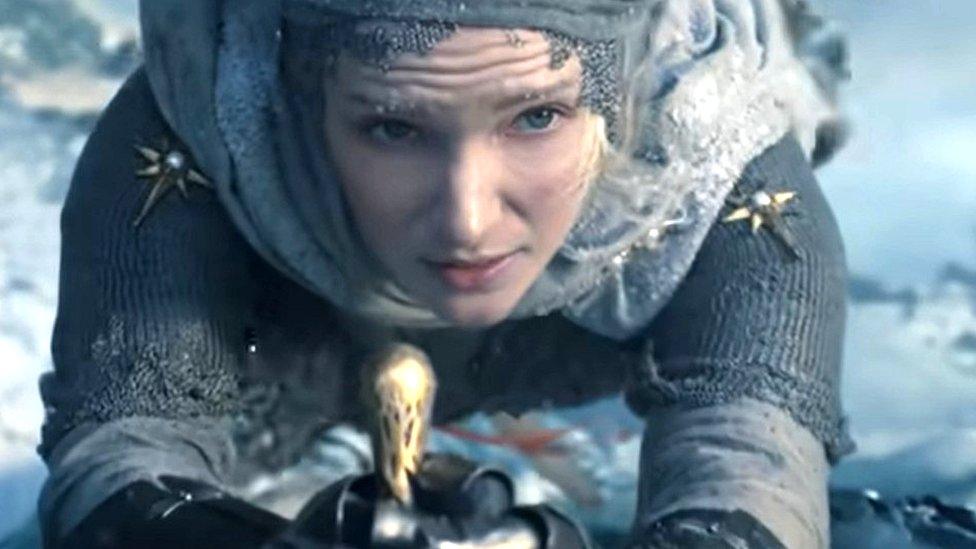 A young Galadriel, played by Morfydd Clark, is shown scaling up an icy cliff face in the new trailer