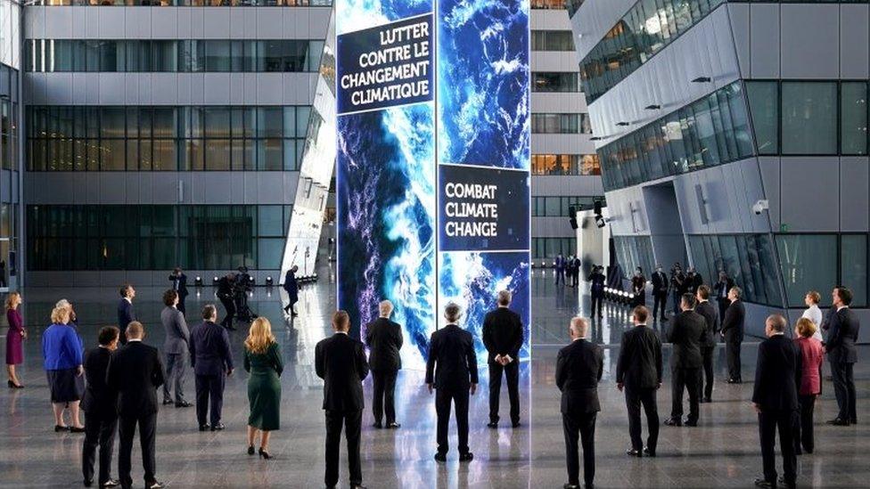 Nato heads of the states and governments look at a digital installation after posing for a family photo, during summit