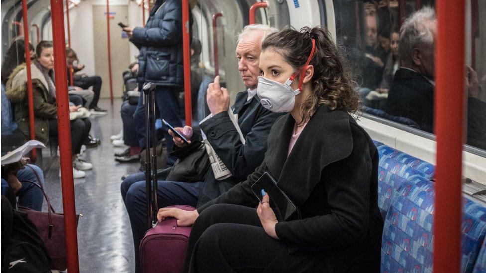 A woman wears a face mask on the London Underground