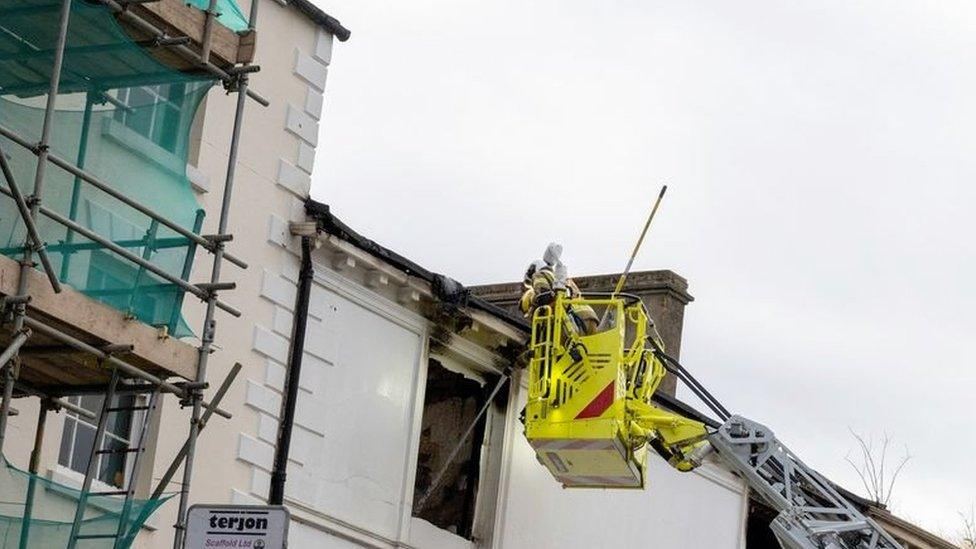 Northamptonshire Fire and Rescue crews inspect the burnt-out building using an aerial platform.