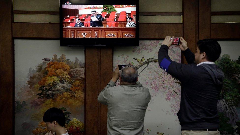 Restaurant diners watch a broadcast of the 7th Congress of the Workers" Party of Korea on local television, where North Korean leader Kim Jong Un is seen delivering a speech