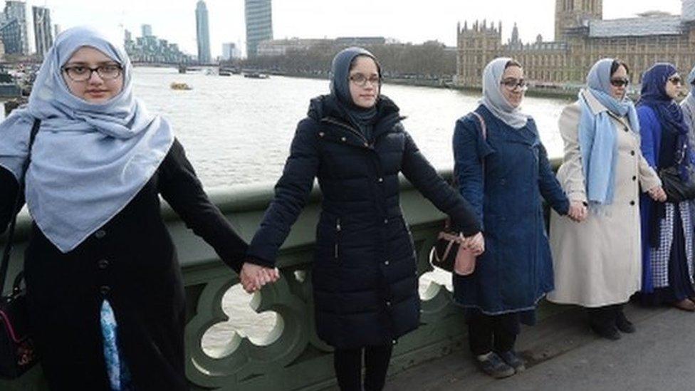 A group of women, some with their daughters, link hands on Westminster bridge