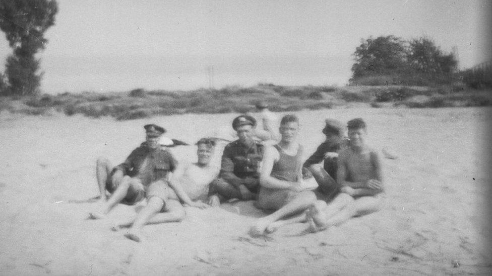 Soldiers sitting on a beach in 1919