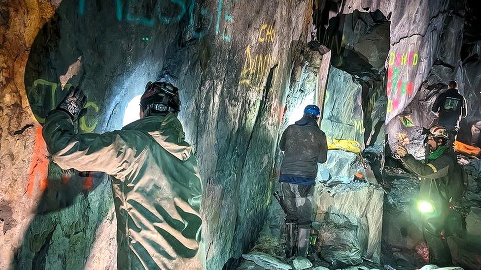 the volunteers at the bottom of a shaft doing graffiti clean-up