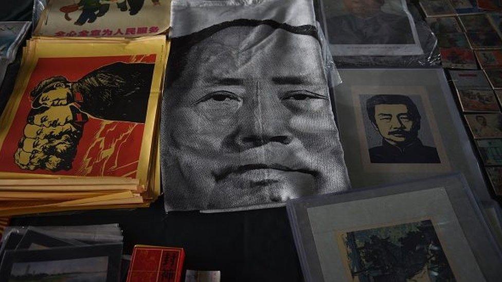 A cloth print featuring a portrait of late communist leader Mao Zedong (C) lies on the ground at a market in Beijing on October 25, 2015