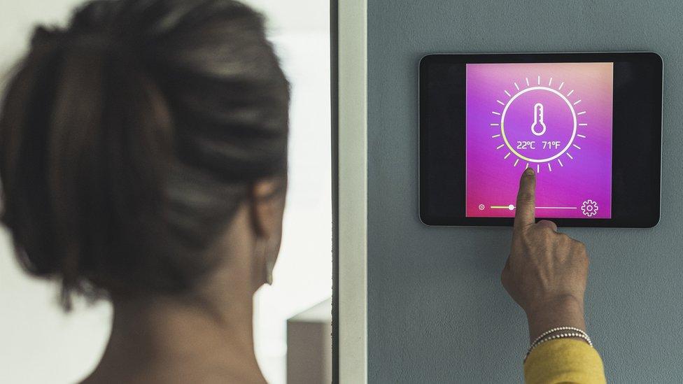 Woman checking thermostat