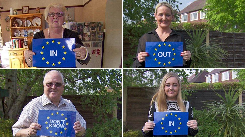 Family holding in and out placards