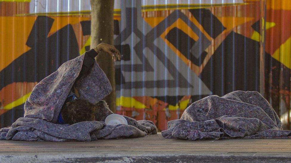 Men huddled under blankets in São Paulo