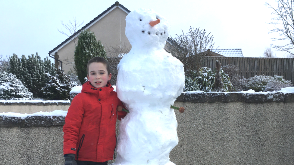a snowman and its young creator