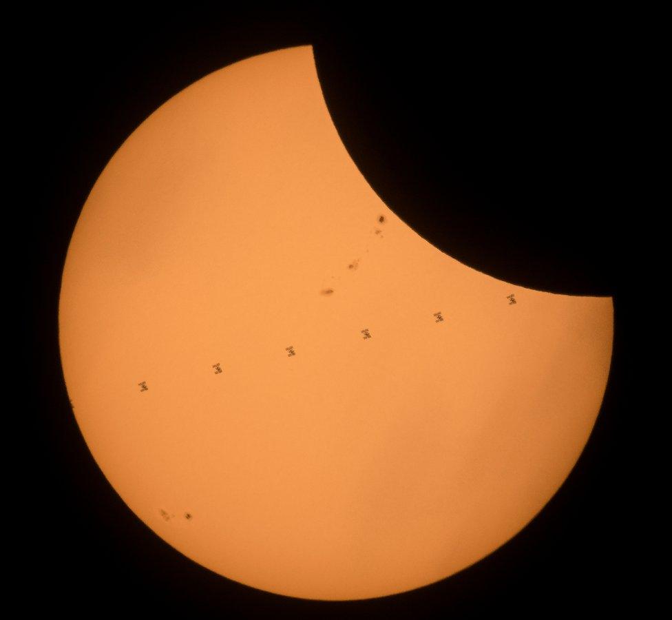 This composite image, made from seven frames, shows the International Space Station, with a crew of six onboard, as it transits the Sun at roughly five miles per second during a partial solar eclipse, Monday, Aug. 21, 2017 near Banner, Wyoming.