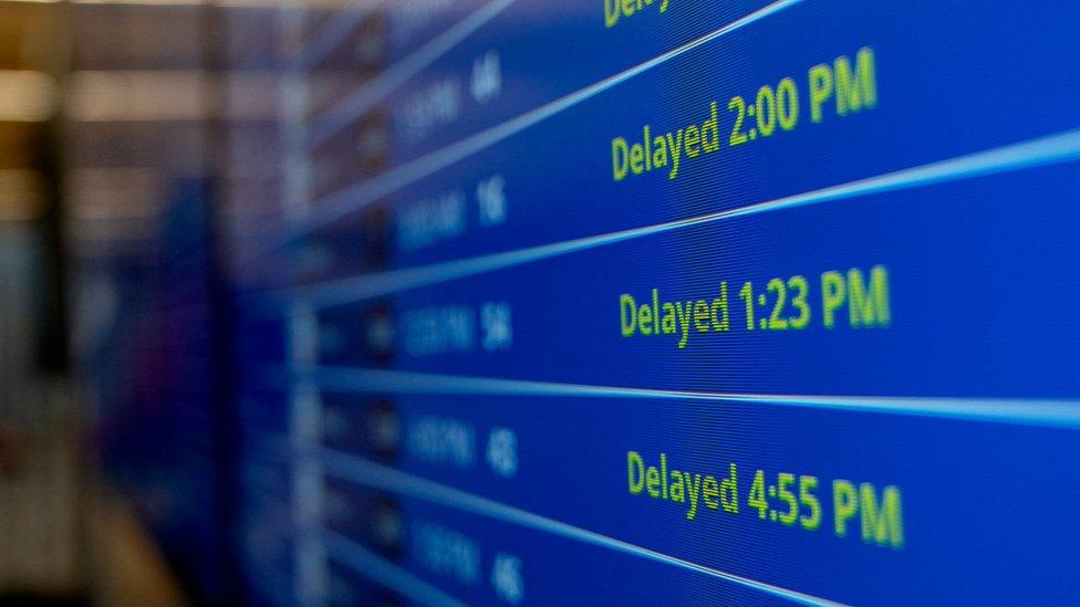 An airport fight information display board showing delays