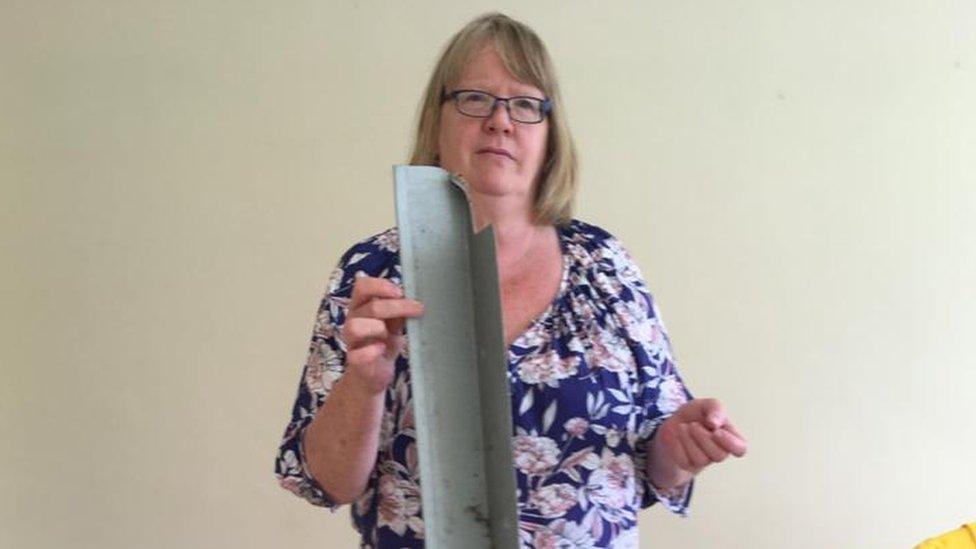 Pauline Sadler holds a piece of cladding