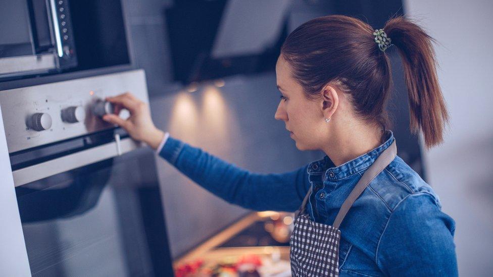 Woman using gas cooker