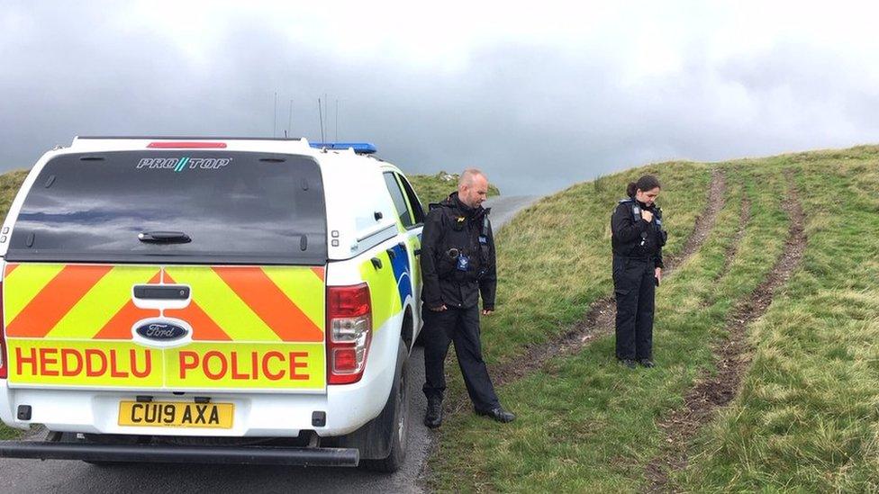 Police officers inspecting damage