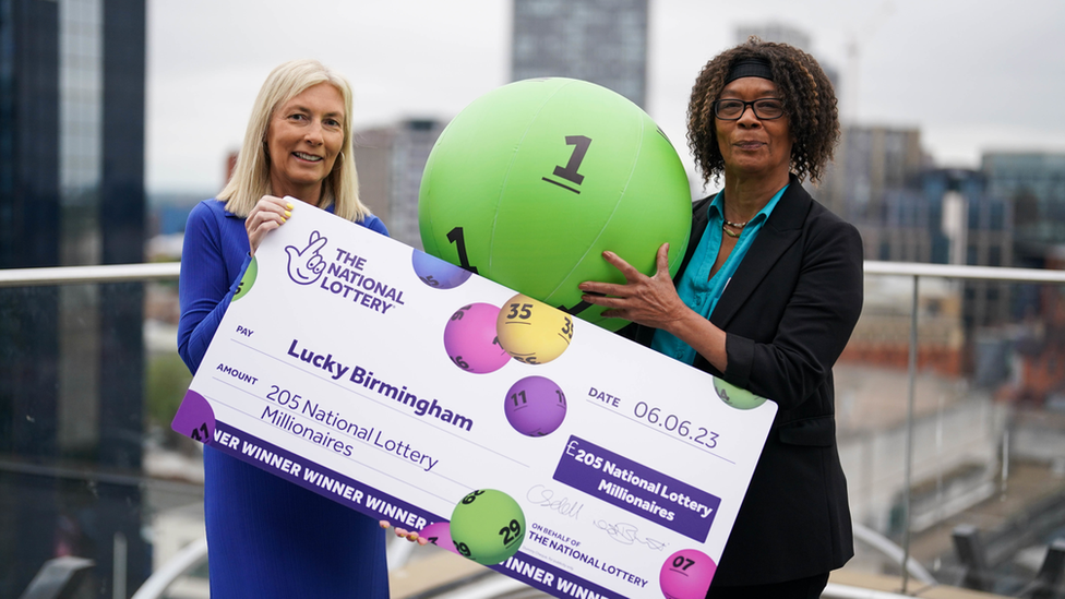 A lottery winner with a giant cheque