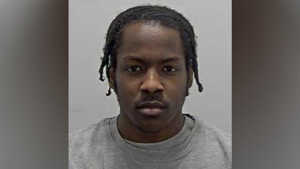 Ahmed Adam: The head and shoulders of a man with black hair wearing a grey. round-necked top.