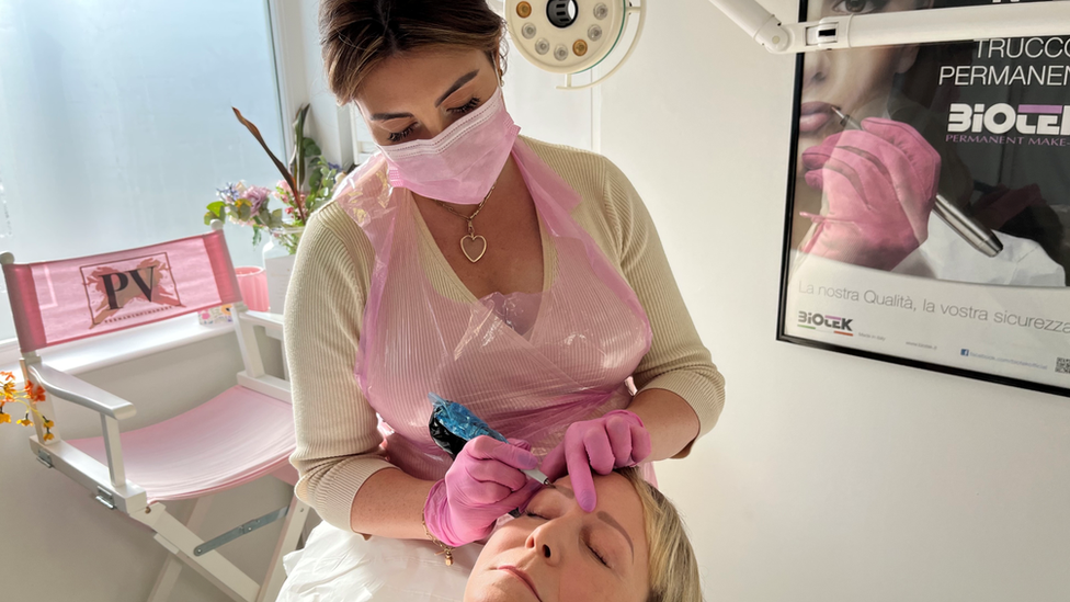 Polly Vincent giving an eyebrow tattoo