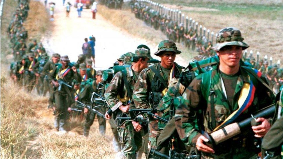 Leftist rebels of the Revolutionary Armed Forces of Colombia (FARC) patrol by a roadway near to San Vicente de Caguan, Caqueta province, Colombia, January 9. 1999