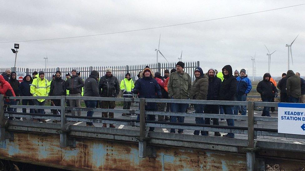 Construction workers outside a power plant