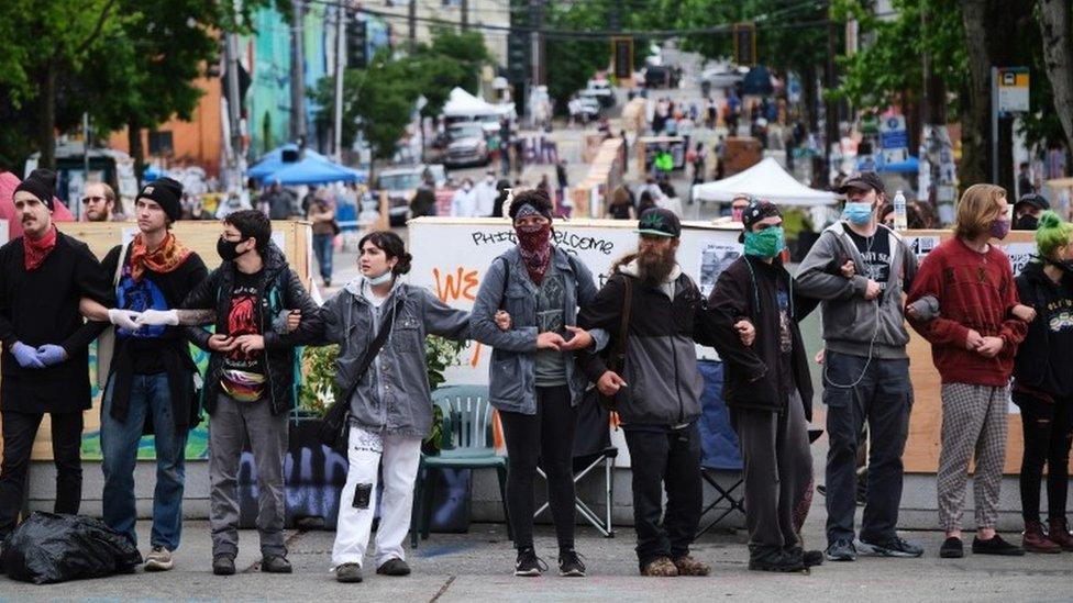 Activists form a wall in an effort to keep out and disruptive protestor in the "Occupied Protest"