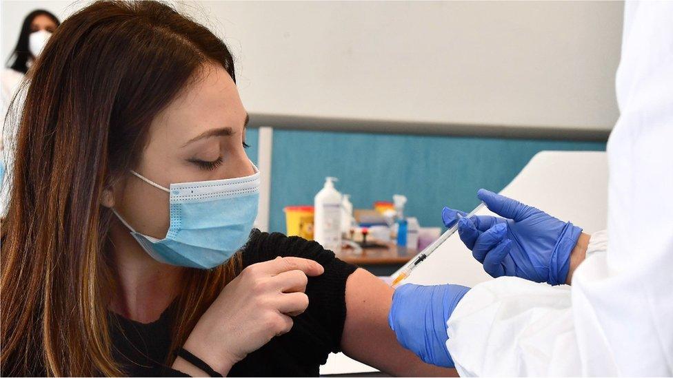 A woman is vaccinated against Covid-19 with the AstraZeneca vaccine in Genoa, Italy, 10 March 2021.