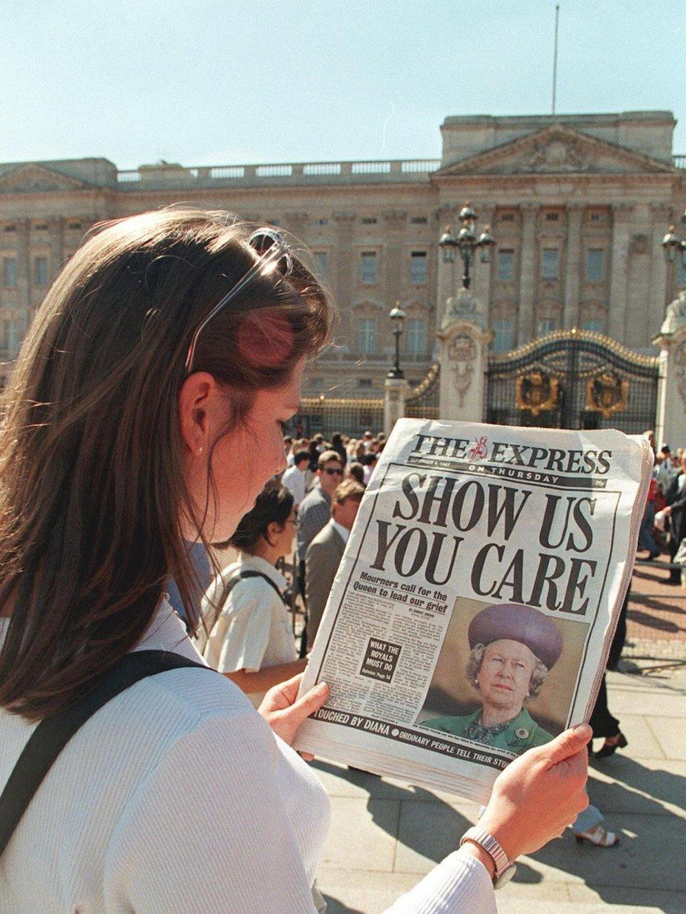 A woman reads a newspaper headline from 4 September 1997, criticising the Queen's silence since the death of Diana, Princess of Wales, the previous weekend