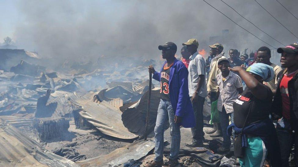 People look at the destruction a fire has done to the stalls