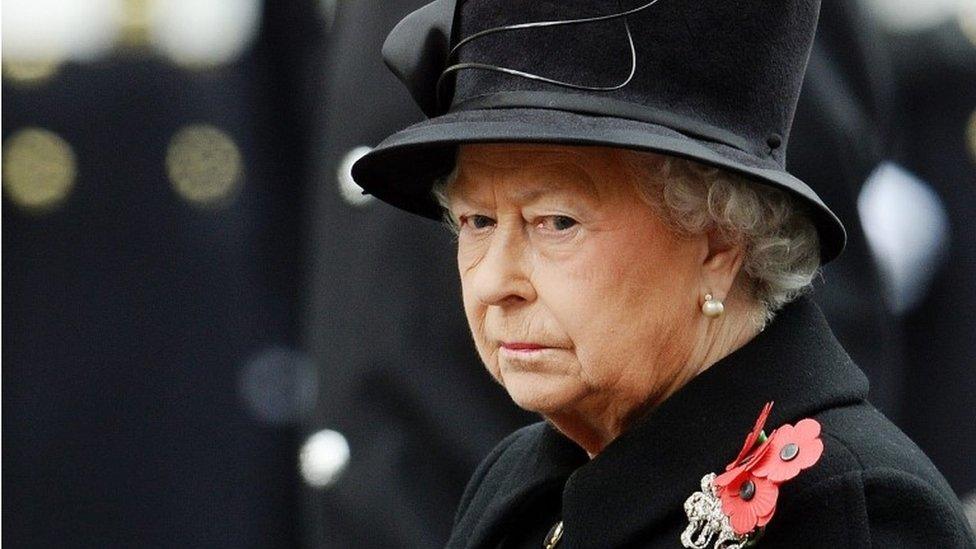 The Queen dressed in black jacket and black hat