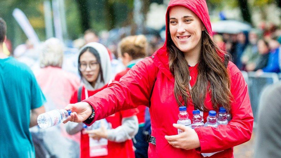 woman handing out water bottles