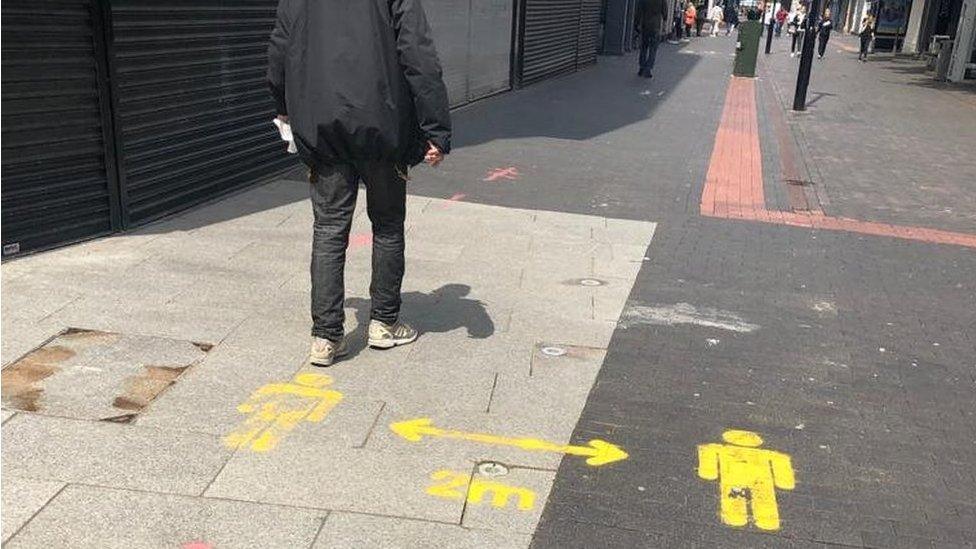 Man walking in Middlesbrough with social distancing sign