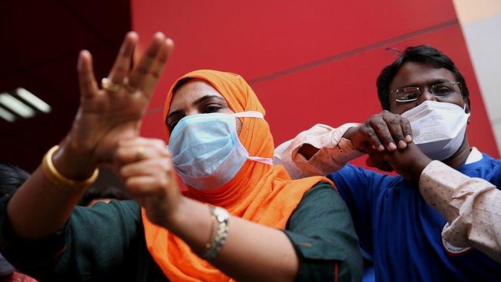 Medical officials in India show to the public how to properly wash their hands using hand sanitisers. File photo