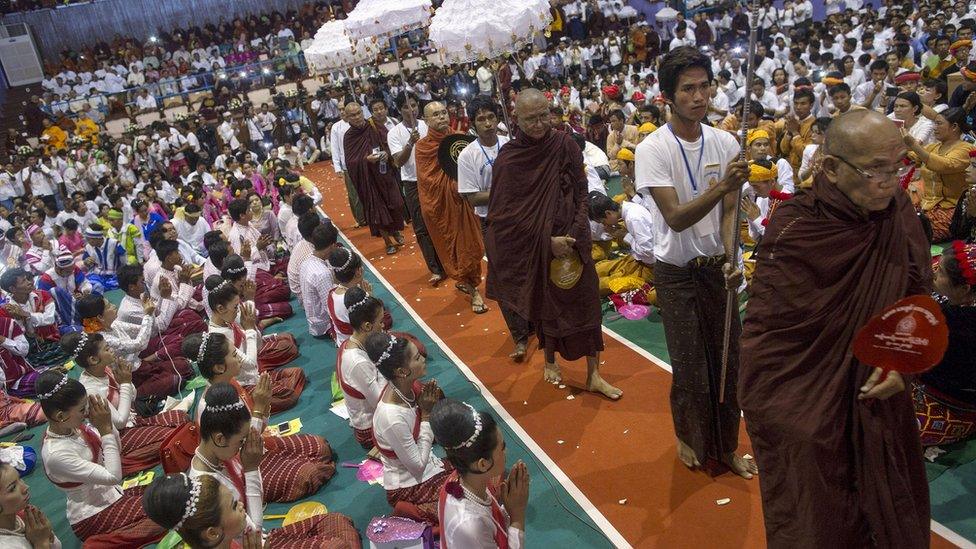 Buddhist monks and supporters celebrate in a stadium at Yangon on Sunday