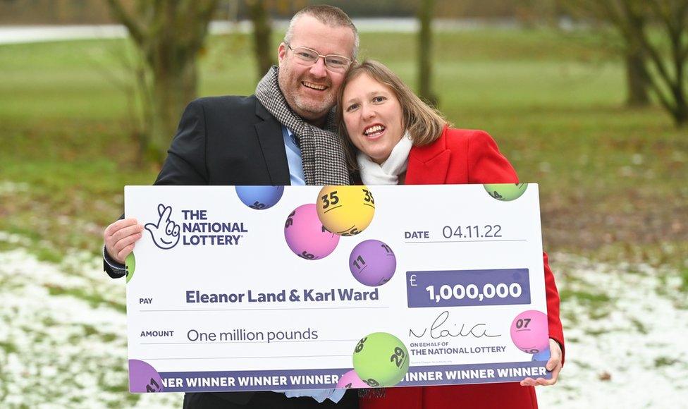 Ellie Land and Karl Ward celebrating their lottery win with a large cheque from the National Lottery