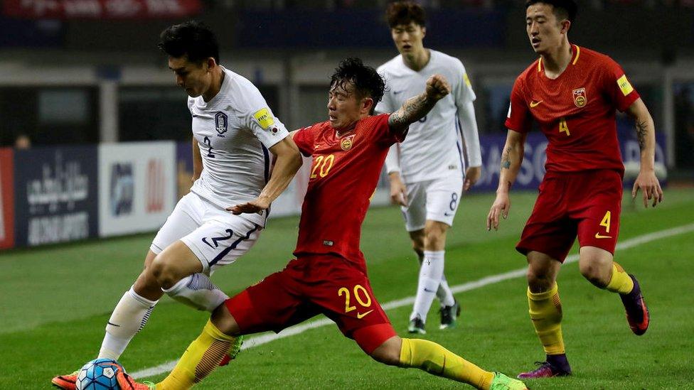 Lee Yong (L) of South Korea is tackled by Zhang Xizhe (C) of China during their World Cup football qualifying match in Changsha, China's central Hunan province on March 23, 2017