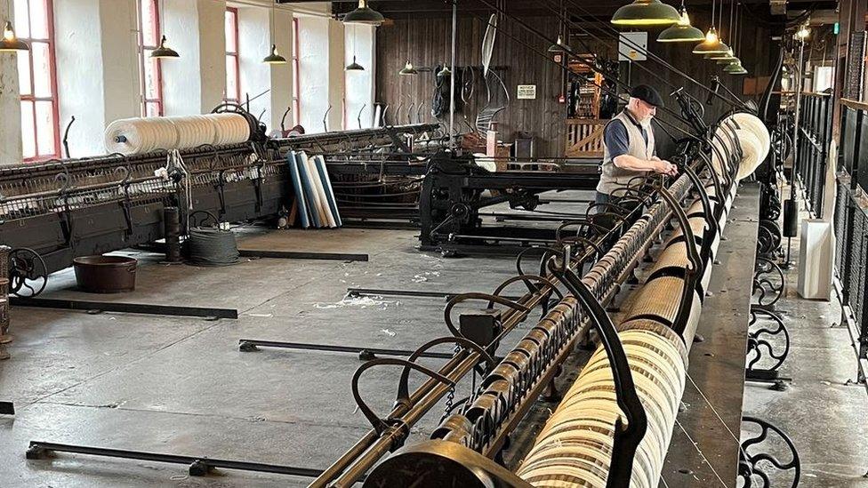 Barrie Mackwell demonstrates how the newly-repaired spinning mule at Leeds Industrial Museum was used to spin fibres into yarn.