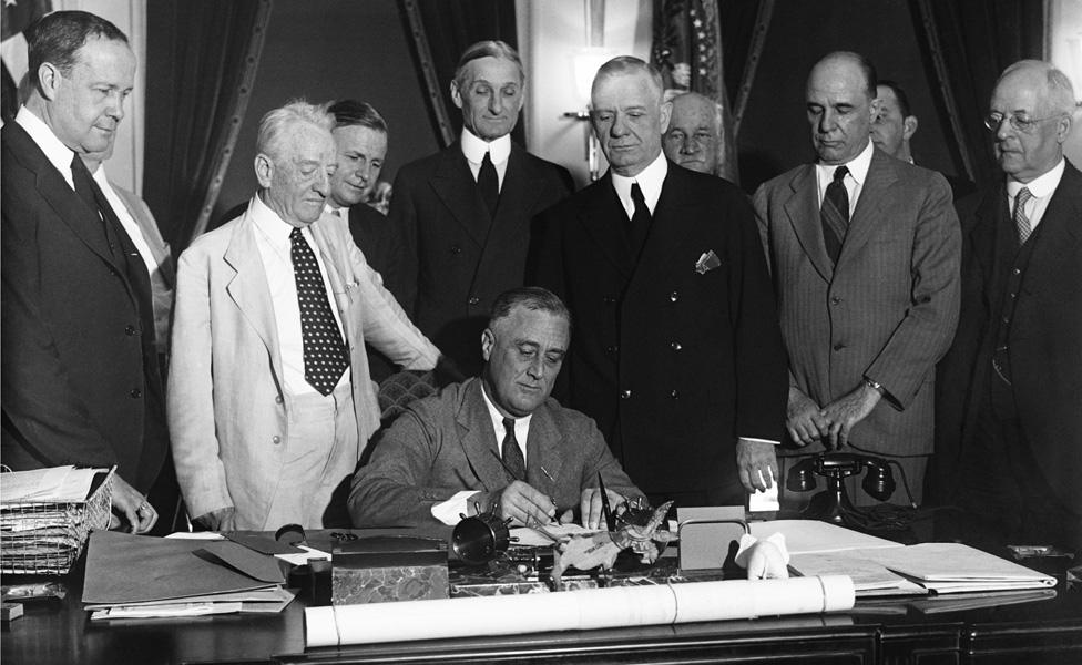 Franklin Roosevelt signs the Glass-Steagall banking reform act on 16 June, 1933.