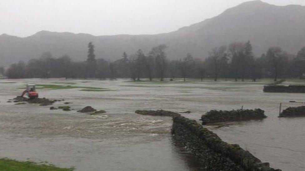 A tractor looks stranded in a flooded field