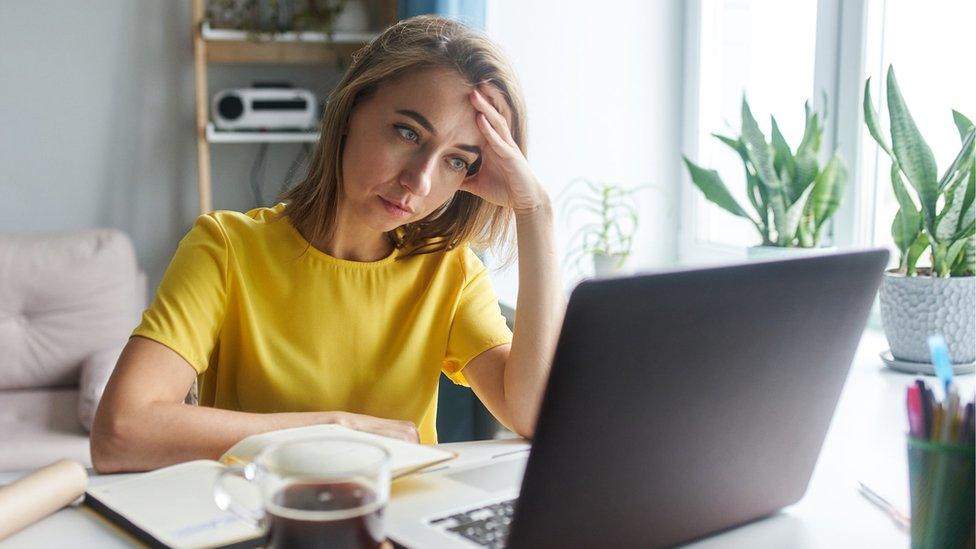 Person looks concered at laptop