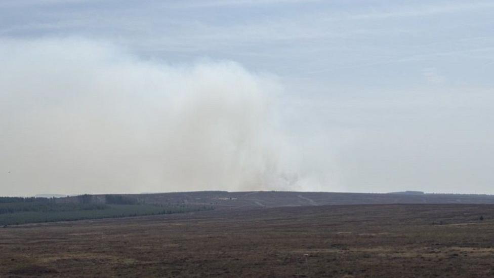 A view of the moorland fire, with smoke seen billowing in the distance around the moors and fields.