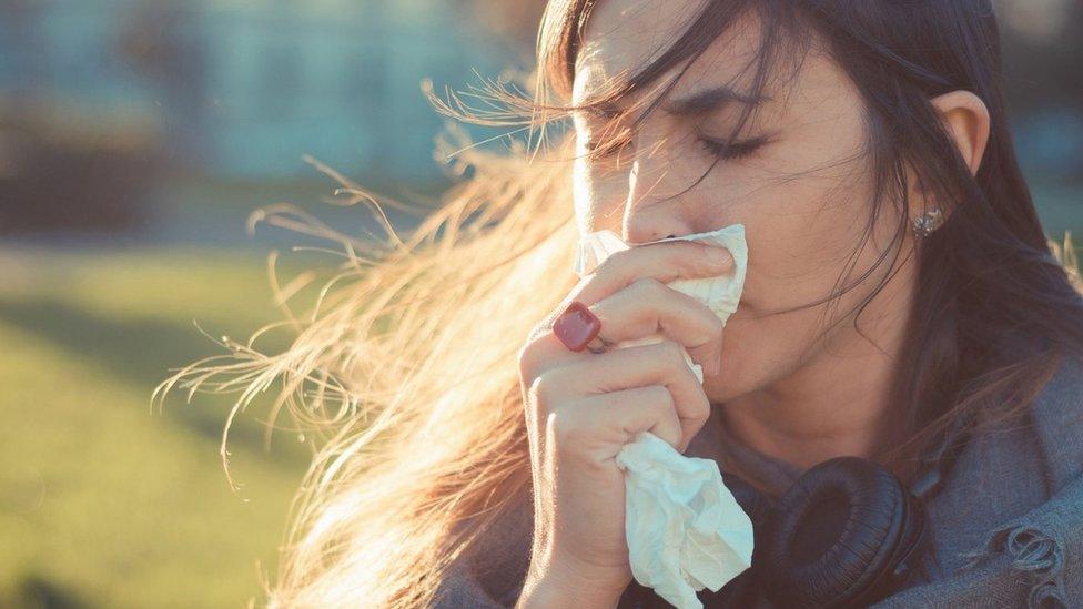 Woman holding a tissue to her nose