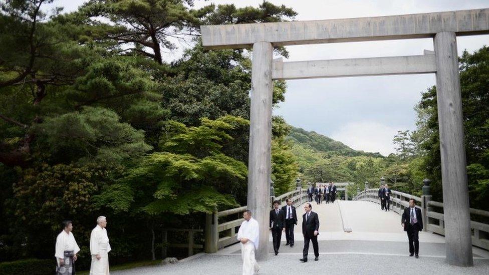 French President Francois Hollande (C) walks under a "torii" or gate, as he arrives at Ise-Jingu Shrine in the city of Ise in Mie prefecture, on May 26, 2016, on the first day of the G7 leaders summit.