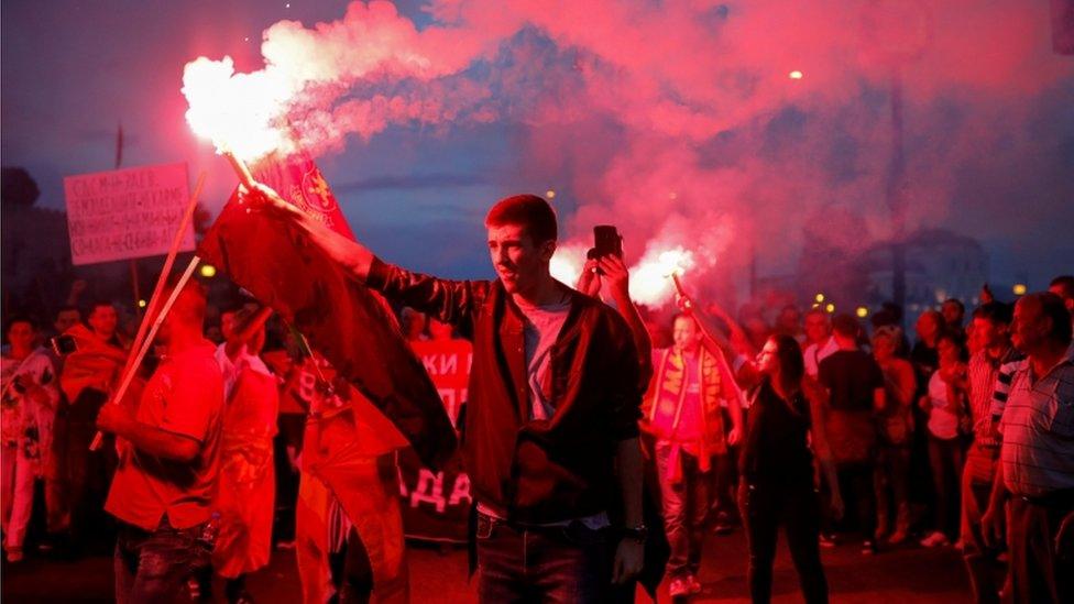 A supporter of opposition party VMRO-DPMNE lights a flare as he takes part in a protest over compromise solution in Macedonia"s dispute with Greece over the country"s name, in Skopje, Macedonia, June 2, 2018.