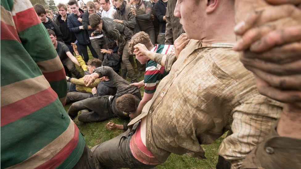 Competitors fight for the bottle on the ground