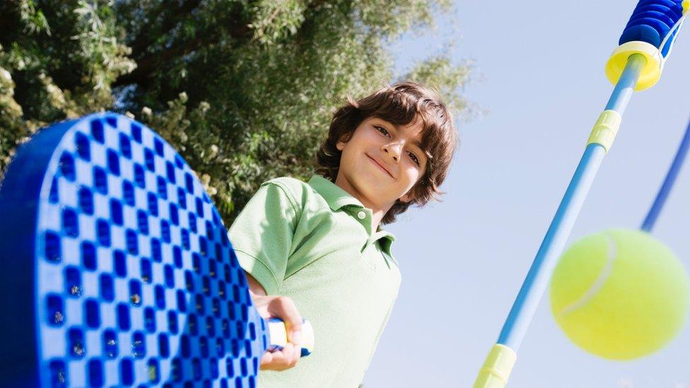 Boy playing swingball