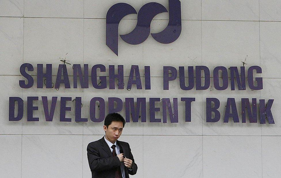 A customer leaves a branch of the Shanghai Pudong Development Bank in Shanghai, 8 June 2006.