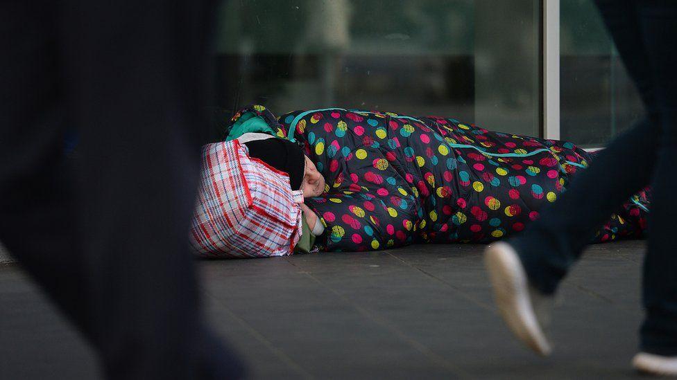 Homeless person sleeping on the ground