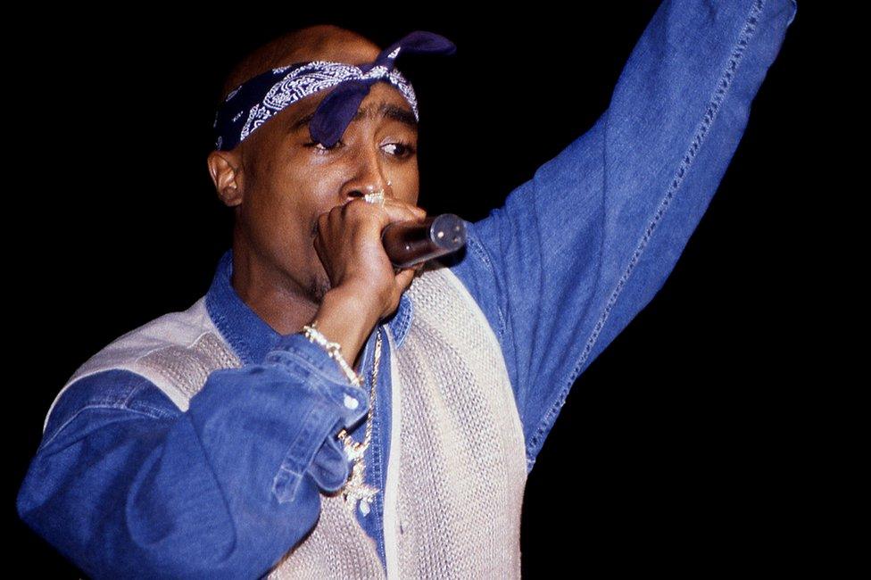 Tupac Shakur performs at a concert